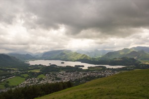 A photo taken from the top of a Lake District 
                         fell looking down on a town and a lake