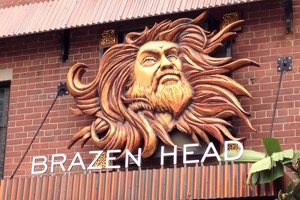 A large, ornate, Zeus-like head over the words 
                         'Brazen Head'